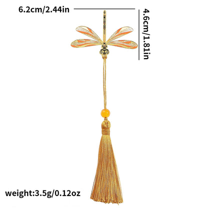 Clairly dragonfly enamel bookmark with orange wings, gold-tone brass detailing, and a matching gold tassel and bead.