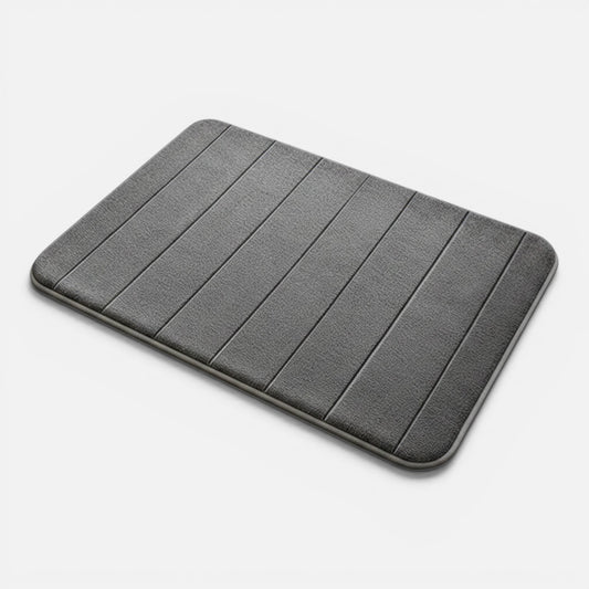 Clairly grey striped absorbent bath mat with plush flannel surface and non-slip base, shown with beige slippers.