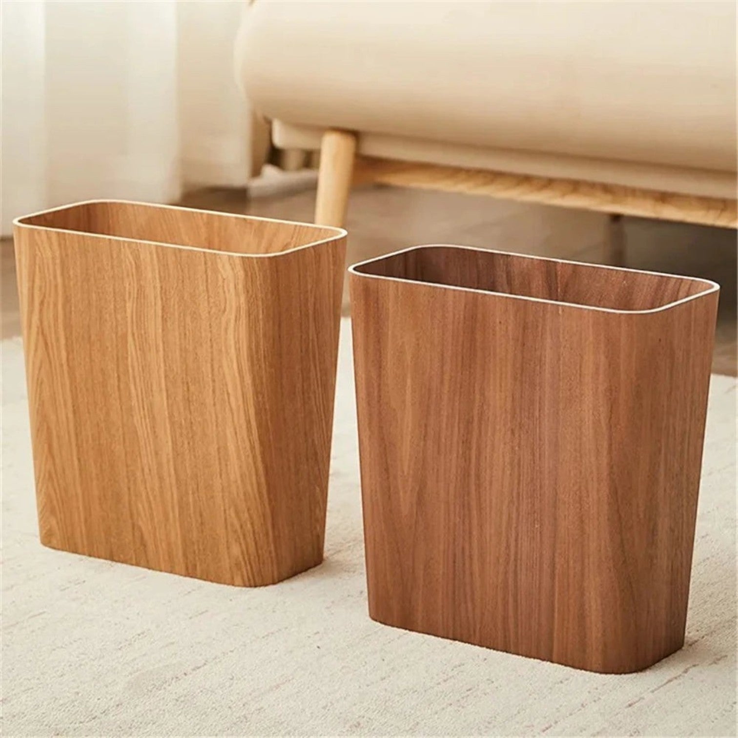 Clairly Japanese style rectangular wooden trash cans in natural oak and walnut finishes on a carpeted floor.