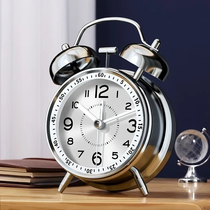 Clairly vintage twin bell alarm clock with a silver alloy frame and white face on a wooden nightstand